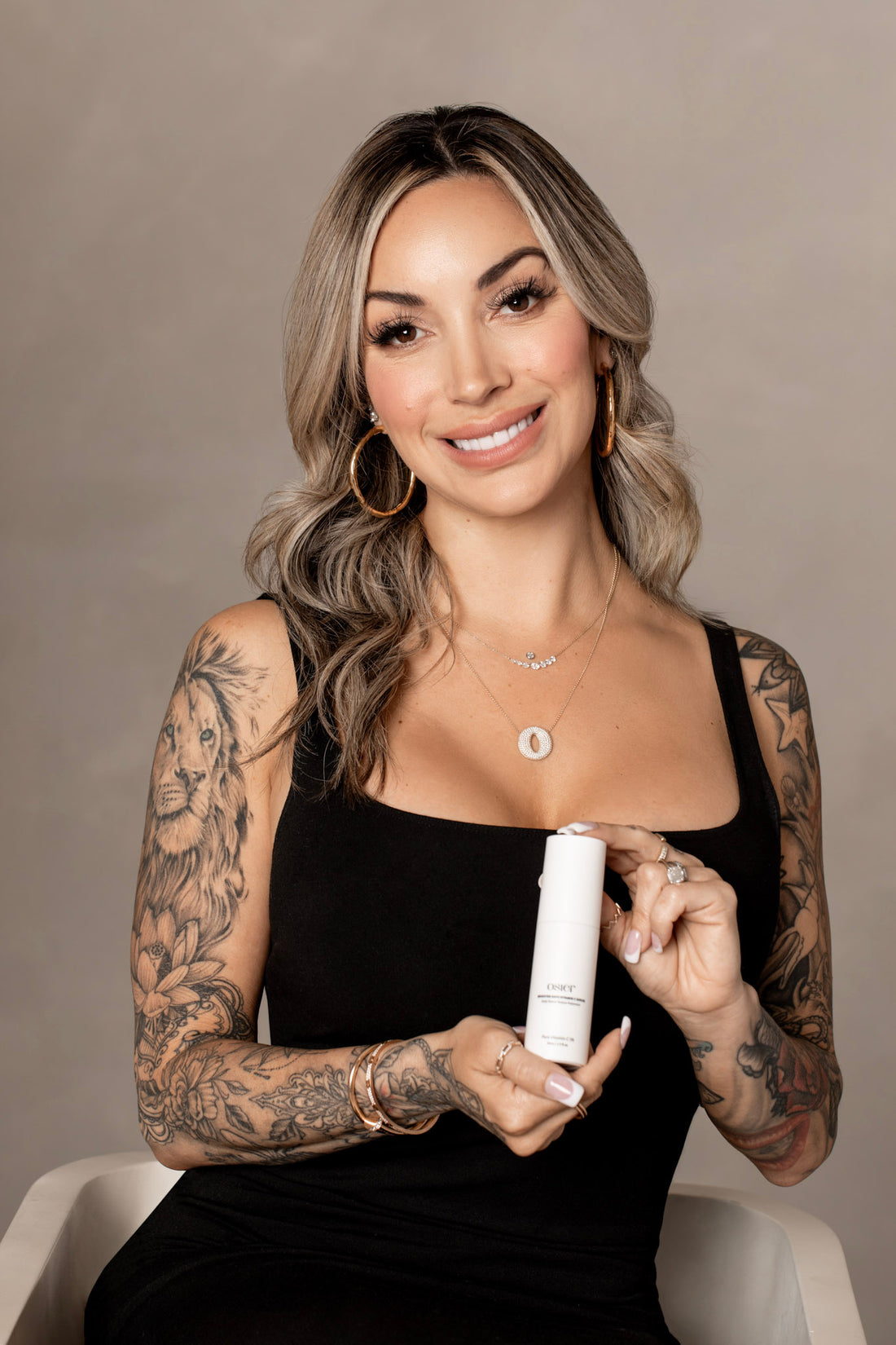 Osier founder Cheree Ashley smiling, holding a bottle of Brighter Days Vitamin C Serum