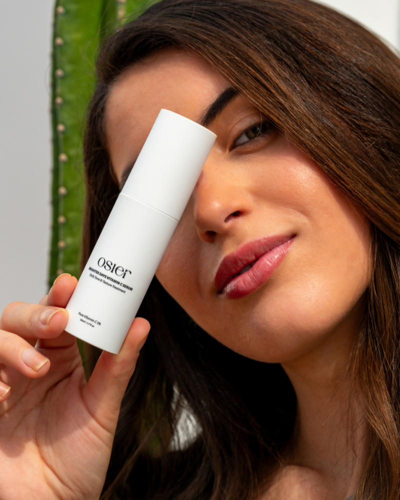 Model holding Osier Vitamin C Serum in front of one eye